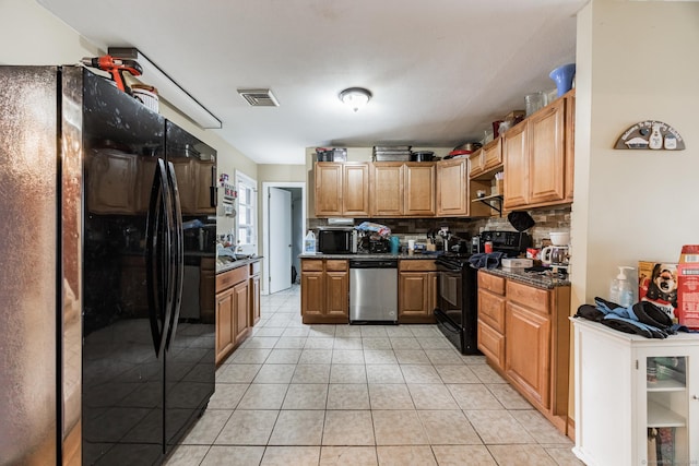 kitchen featuring light tile patterned floors, backsplash, and black appliances