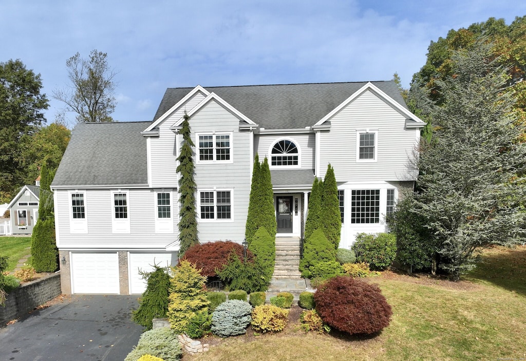 view of front property featuring a garage and a front yard