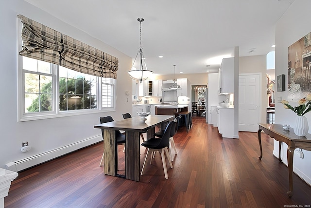 dining area with dark hardwood / wood-style flooring and a baseboard heating unit