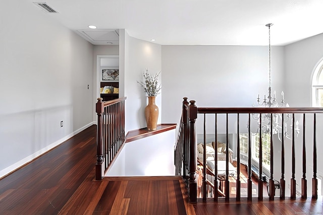 hall with dark hardwood / wood-style floors and an inviting chandelier