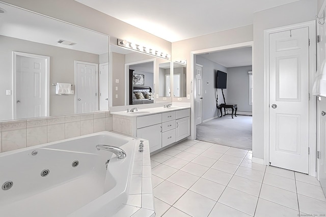 bathroom featuring tile patterned floors, vanity, and a relaxing tiled tub