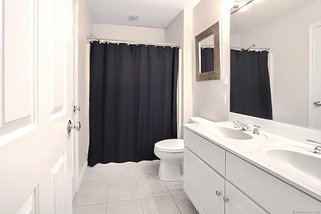 bathroom with tile patterned flooring, vanity, and toilet