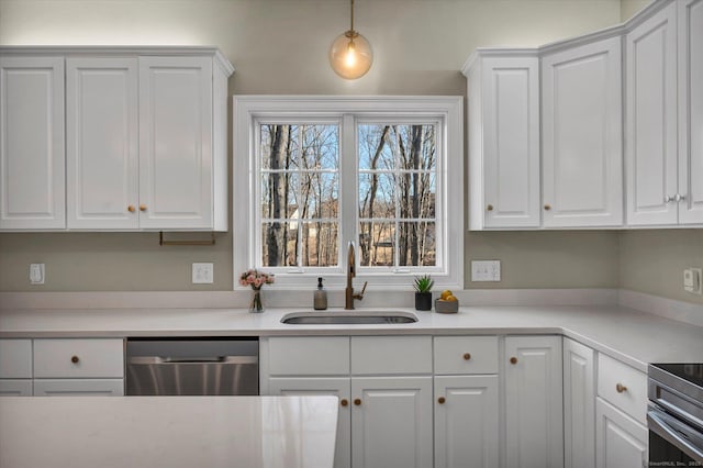 kitchen featuring sink, stainless steel dishwasher, decorative light fixtures, white cabinets, and range