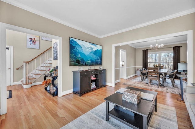 living room with light hardwood / wood-style flooring, a notable chandelier, and ornamental molding