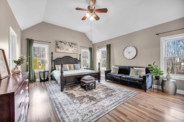 bedroom featuring light hardwood / wood-style floors, vaulted ceiling, and ceiling fan