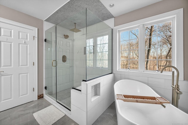 bathroom with separate shower and tub and tile walls