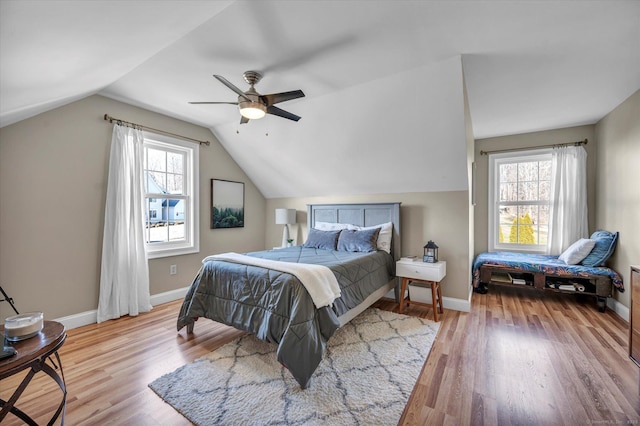 bedroom with light wood-type flooring, vaulted ceiling, and ceiling fan