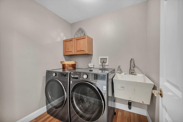 laundry room featuring hardwood / wood-style floors, independent washer and dryer, and sink