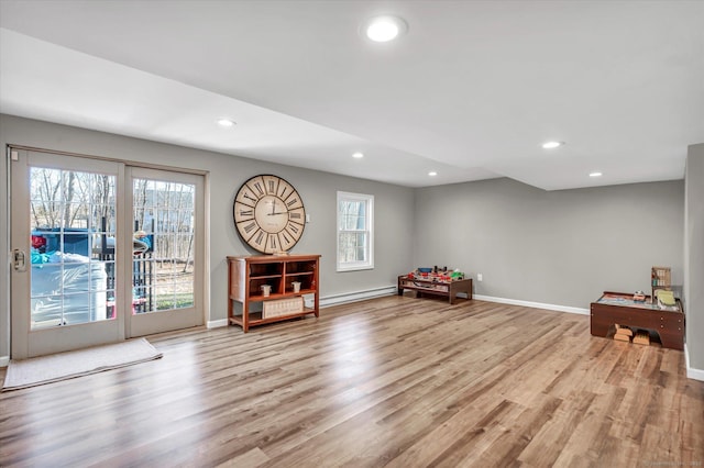 living area featuring a baseboard heating unit and light wood-type flooring