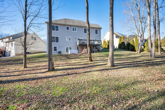 rear view of house featuring a lawn and a deck