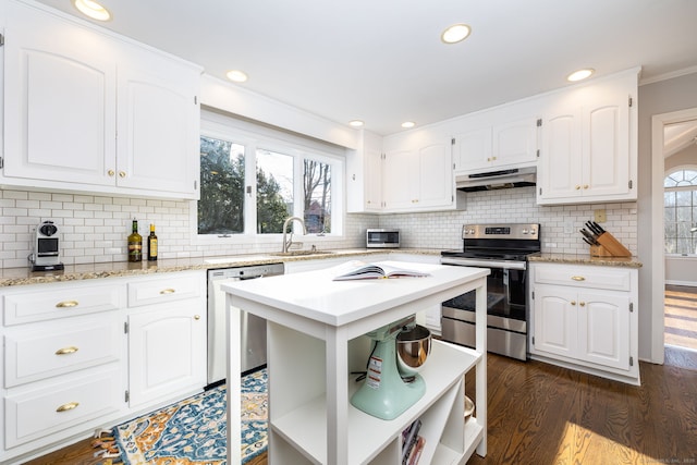 kitchen featuring sink, white cabinetry, a center island, appliances with stainless steel finishes, and dark hardwood / wood-style flooring