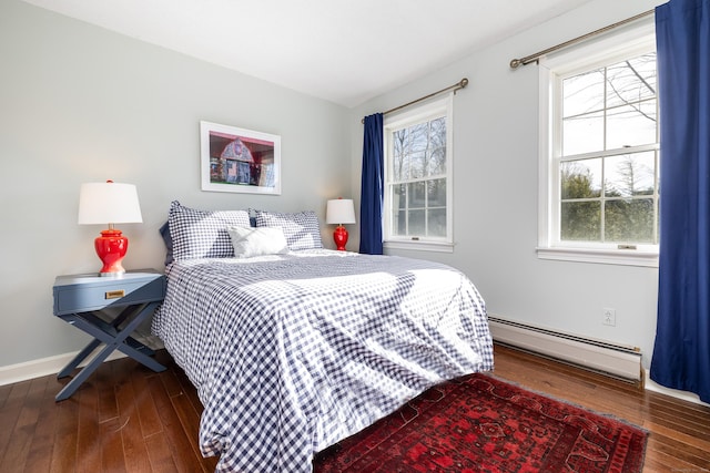 bedroom with dark wood-type flooring and a baseboard heating unit