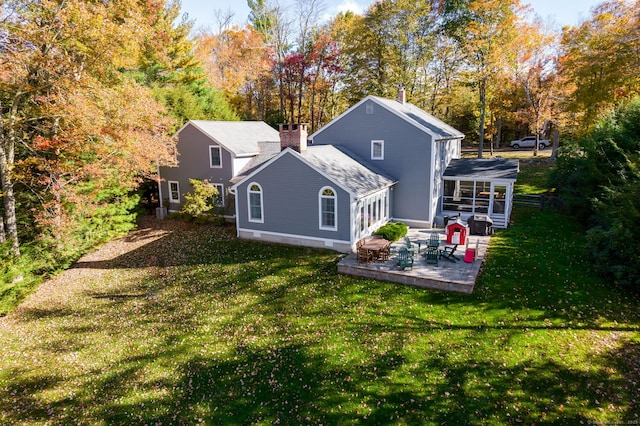 rear view of house with a lawn, a sunroom, and a patio