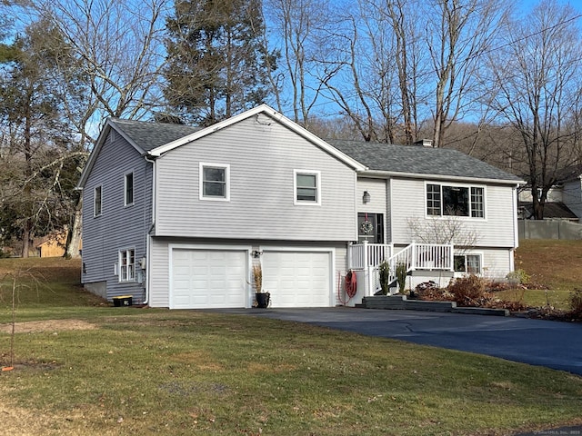 bi-level home featuring a garage and a front yard