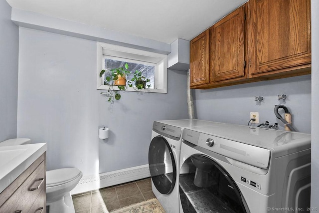 laundry area with separate washer and dryer, a baseboard heating unit, and dark tile patterned floors