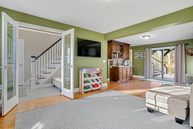 living room featuring french doors and light hardwood / wood-style flooring