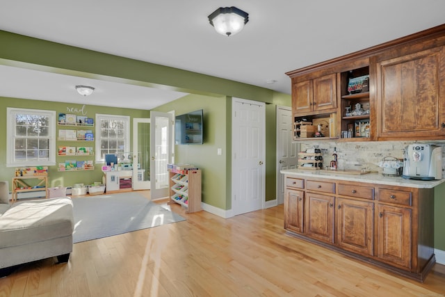 kitchen featuring tasteful backsplash and light hardwood / wood-style flooring