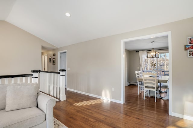 living room with a baseboard heating unit, dark wood-type flooring, an inviting chandelier, and lofted ceiling