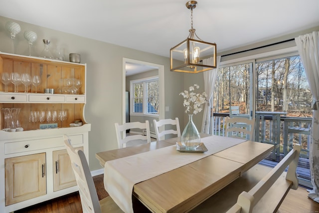 dining space with a wealth of natural light, a chandelier, and dark hardwood / wood-style floors