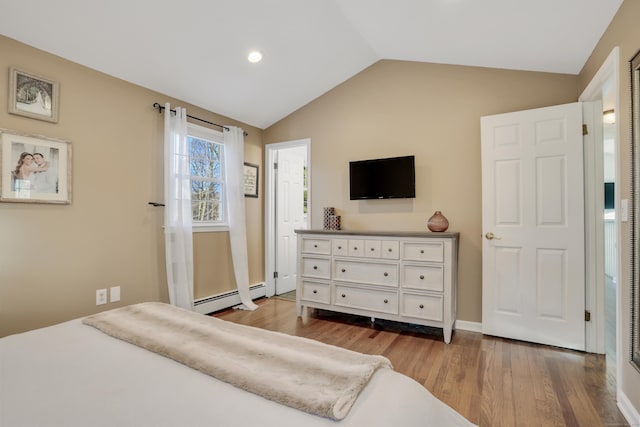 bedroom featuring baseboard heating, vaulted ceiling, and hardwood / wood-style flooring