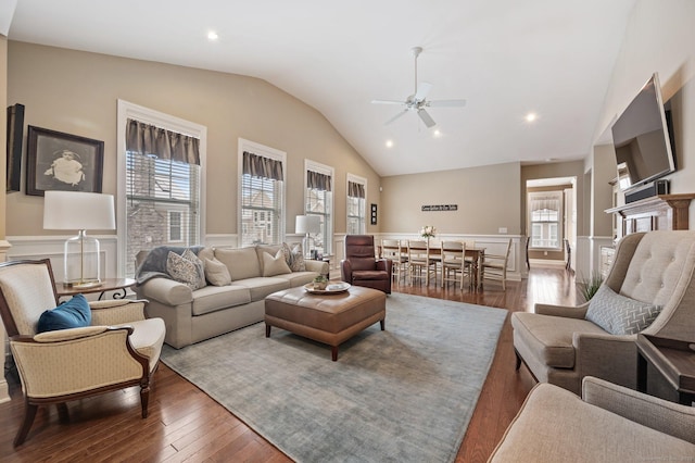 living room featuring dark hardwood / wood-style flooring, vaulted ceiling, a wealth of natural light, and ceiling fan