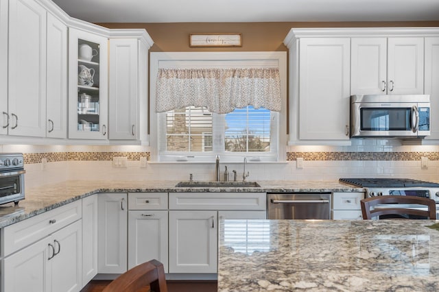 kitchen with tasteful backsplash, white cabinetry, sink, and appliances with stainless steel finishes