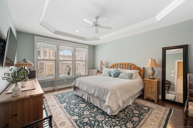 bedroom featuring ceiling fan, dark hardwood / wood-style floors, a raised ceiling, and ornamental molding