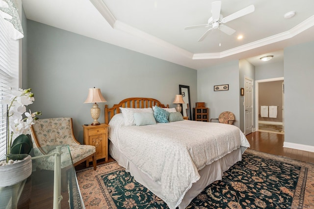 bedroom featuring hardwood / wood-style flooring, ceiling fan, ornamental molding, a tray ceiling, and a closet