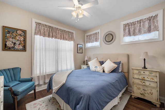 bedroom featuring ceiling fan, dark hardwood / wood-style floors, and multiple windows