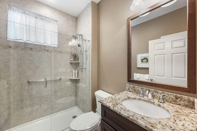 bathroom with vanity, toilet, and a shower with door