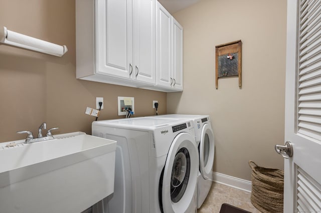 washroom with cabinets, light tile patterned floors, washing machine and dryer, and sink