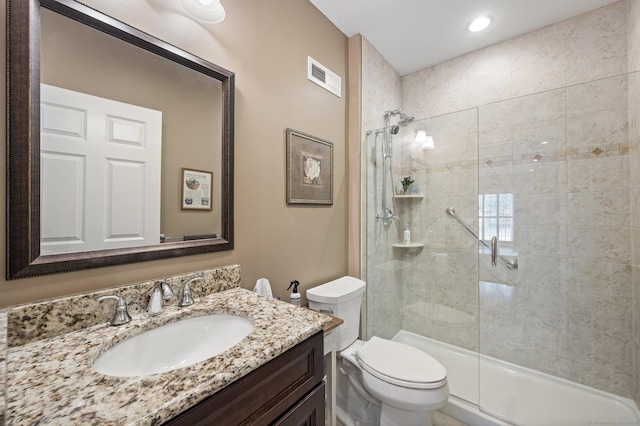 bathroom with vanity, a shower with shower door, and toilet