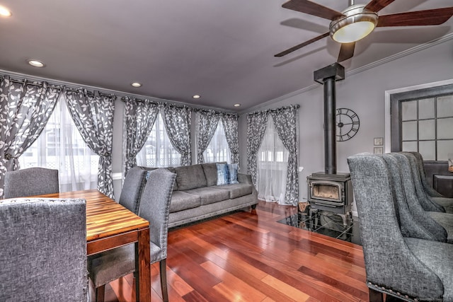 living room featuring a wood stove, crown molding, hardwood / wood-style floors, and plenty of natural light