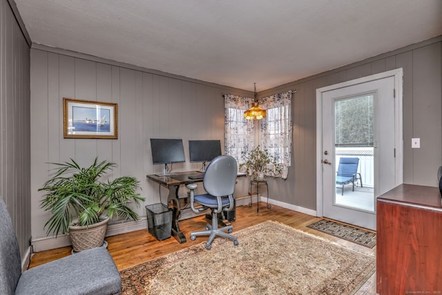 home office with light wood-type flooring and a textured ceiling