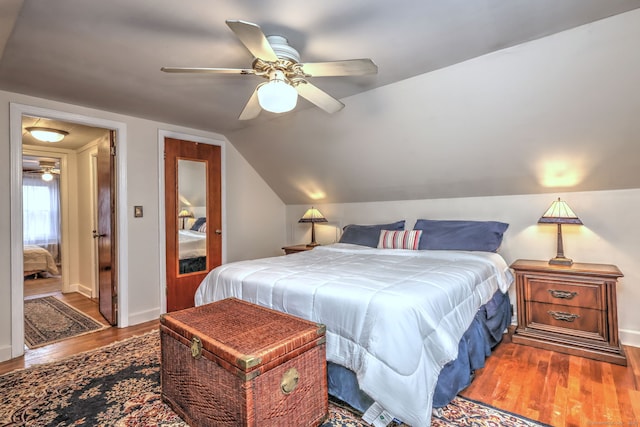 bedroom with hardwood / wood-style flooring, ceiling fan, and lofted ceiling