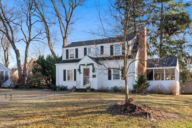 view of front of property featuring a front lawn and a sunroom