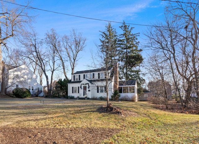 view of front of property with a front yard and a sunroom