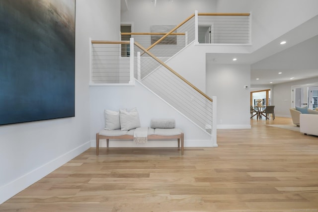 interior space featuring a towering ceiling and hardwood / wood-style flooring