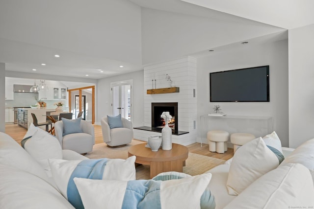 living room with a large fireplace and light wood-type flooring