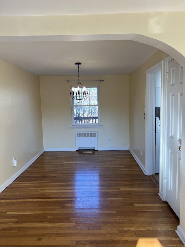 unfurnished dining area with a notable chandelier, dark hardwood / wood-style flooring, and radiator