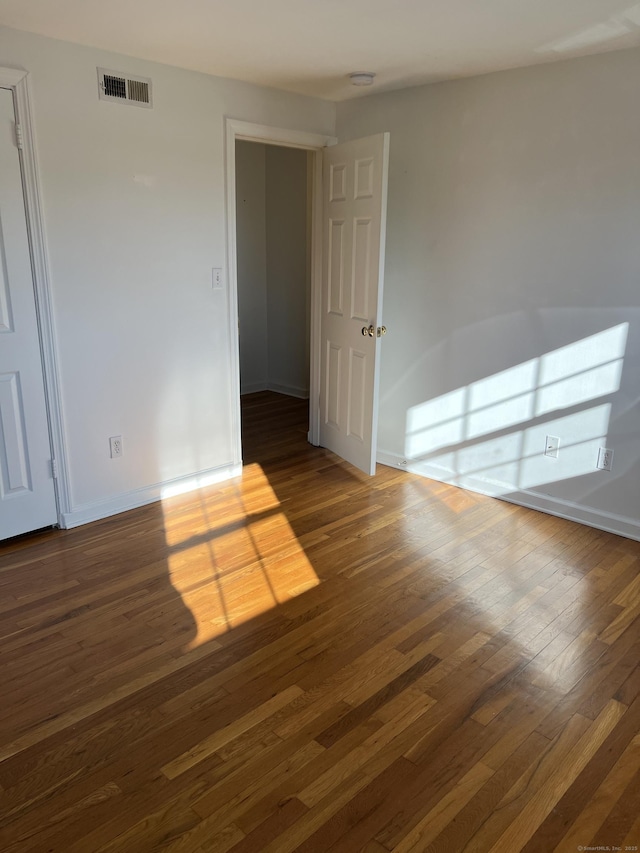 unfurnished room with dark hardwood / wood-style flooring