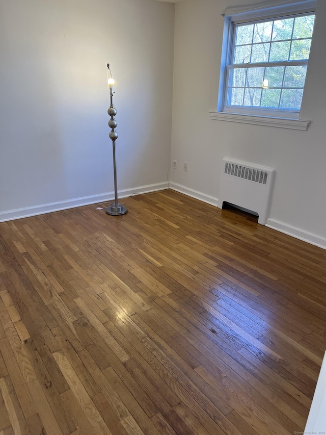 unfurnished room with dark wood-type flooring and radiator