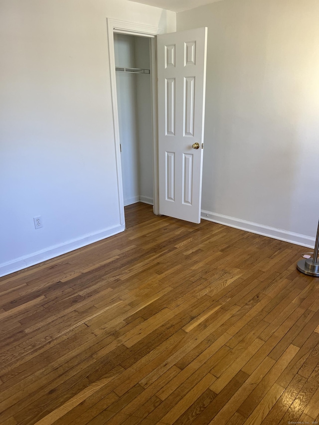 unfurnished bedroom featuring dark hardwood / wood-style floors and a closet