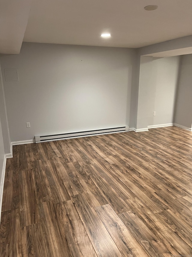 basement featuring dark hardwood / wood-style floors and a baseboard heating unit