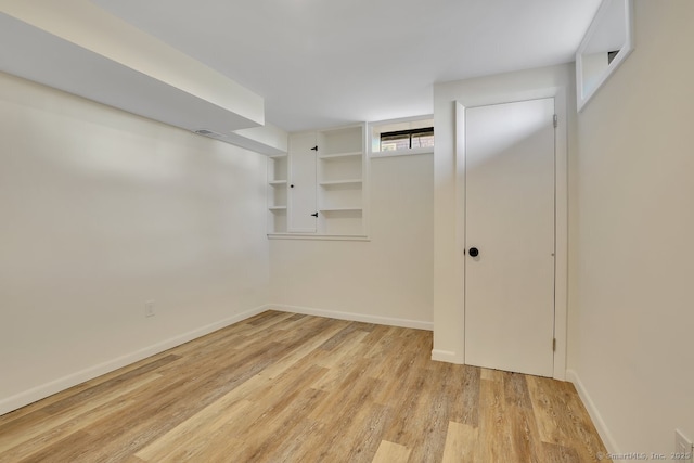 walk in closet with light hardwood / wood-style floors