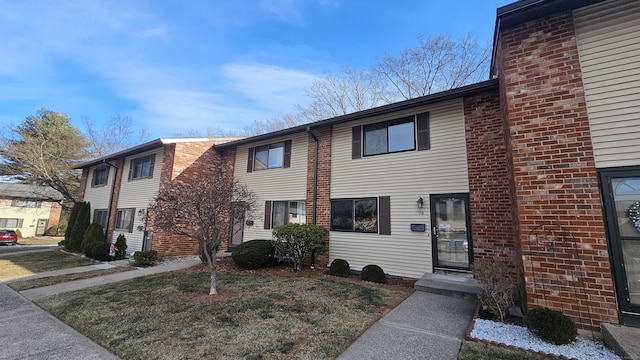 townhome / multi-family property featuring a front lawn