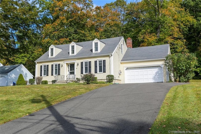 new england style home featuring a garage and a front lawn