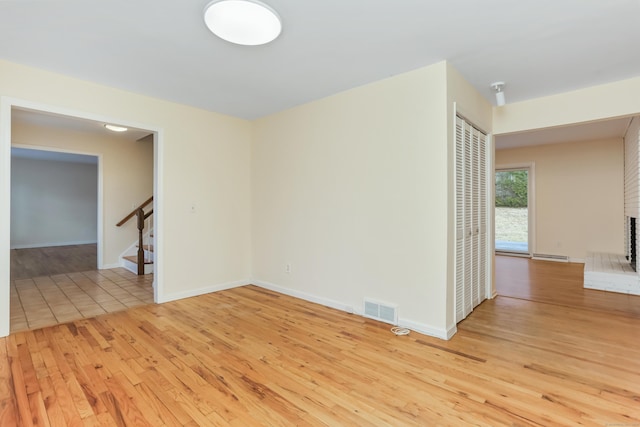 empty room featuring a fireplace and light hardwood / wood-style flooring