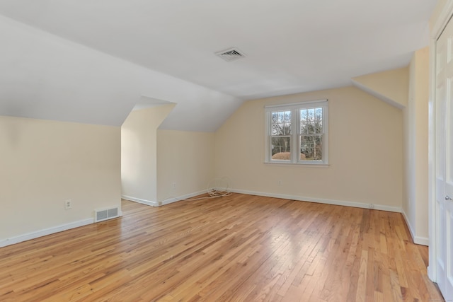 additional living space featuring light hardwood / wood-style flooring and vaulted ceiling