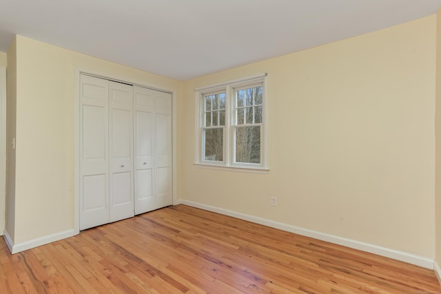 unfurnished bedroom with a closet and light hardwood / wood-style floors